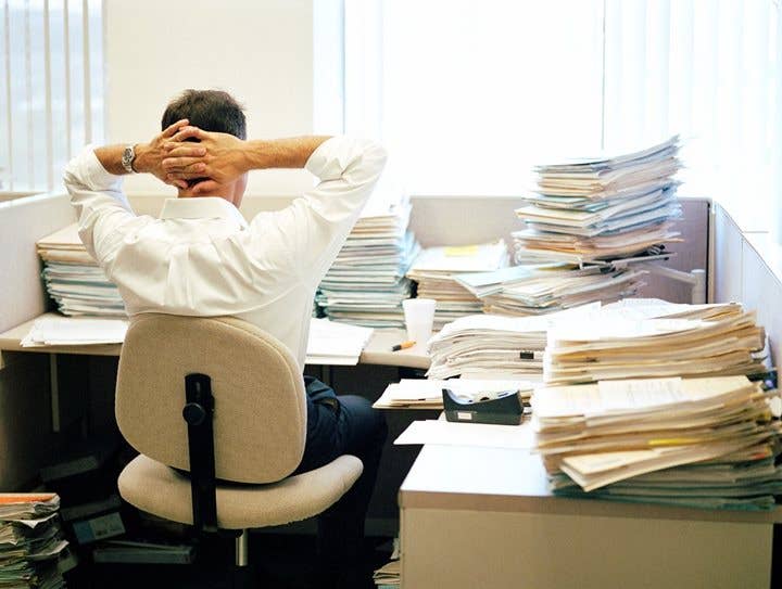 Mann an unordentlichem Bürotisch